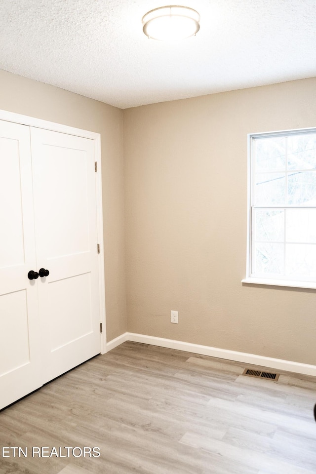 interior space featuring a textured ceiling and light hardwood / wood-style flooring