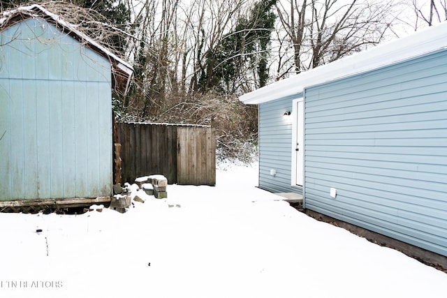 yard layered in snow with a shed