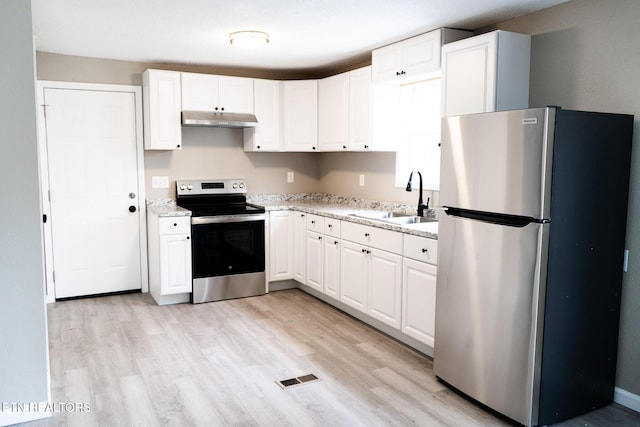 kitchen with light wood finished floors, visible vents, appliances with stainless steel finishes, a sink, and under cabinet range hood