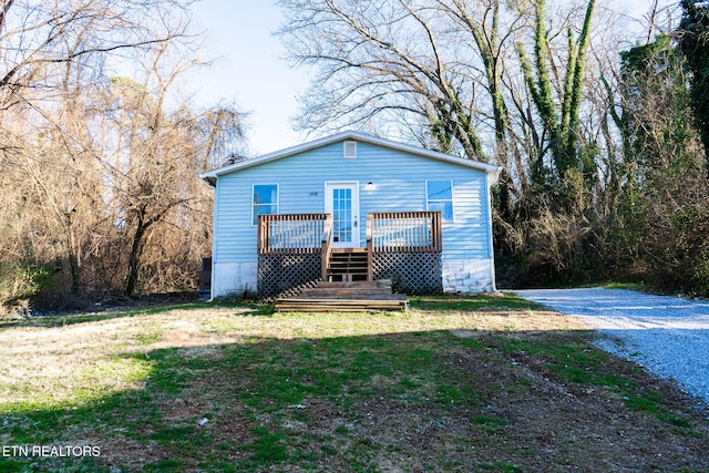 rear view of property with a lawn and a wooden deck