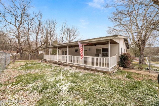 back of property featuring a lawn and covered porch