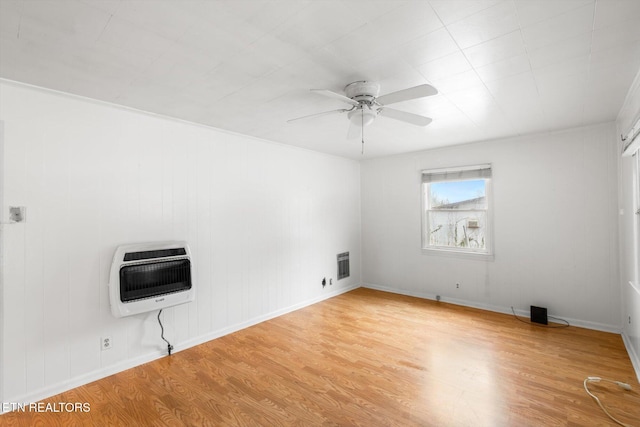 unfurnished room with heating unit, ceiling fan, and light hardwood / wood-style floors