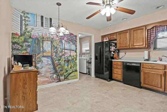 kitchen with ceiling fan with notable chandelier, pendant lighting, black appliances, and washing machine and dryer