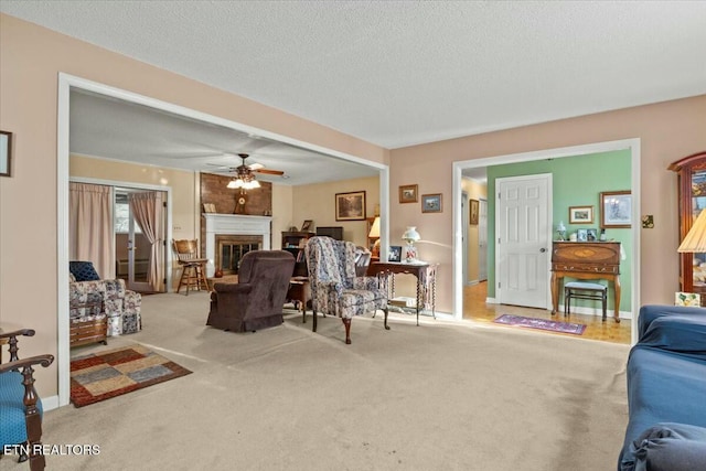 living room with a textured ceiling, ceiling fan, and carpet flooring