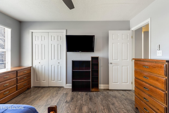 bedroom featuring a closet, ceiling fan, dark wood-type flooring, and a textured ceiling