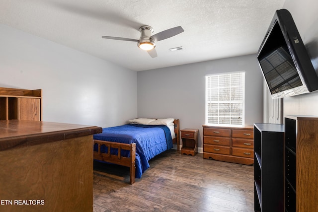 bedroom with a textured ceiling, dark hardwood / wood-style floors, and ceiling fan