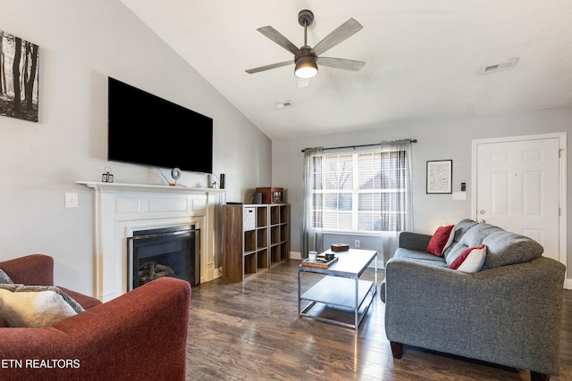 living room featuring dark hardwood / wood-style floors, vaulted ceiling, and ceiling fan