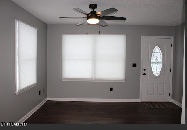 entrance foyer featuring dark wood-type flooring, ceiling fan, and a textured ceiling