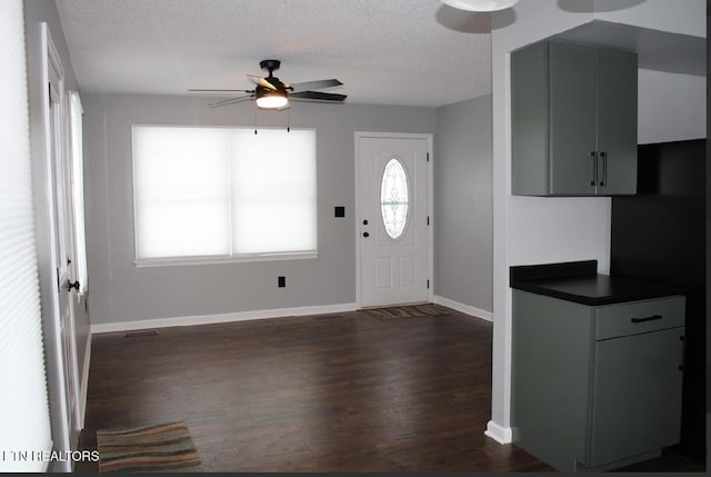 entrance foyer featuring dark wood-type flooring, ceiling fan, and a textured ceiling