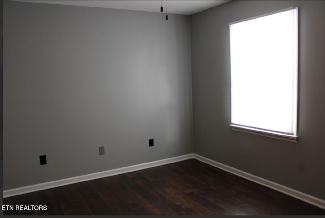 spare room with dark hardwood / wood-style flooring