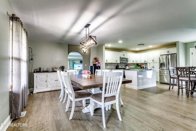 dining space with light hardwood / wood-style floors and sink