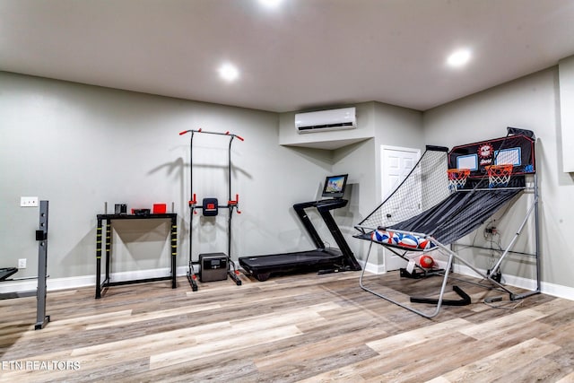 exercise area featuring wood-type flooring and a wall unit AC