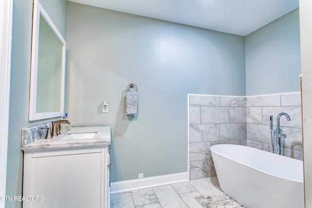 bathroom featuring vanity, a tub, and tile walls