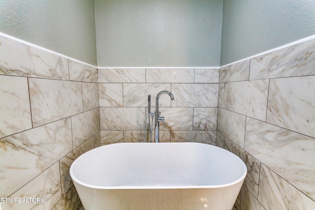 bathroom featuring a bathtub and tile walls