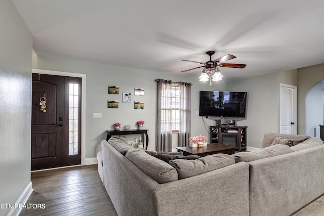 living room with ceiling fan and dark wood-type flooring