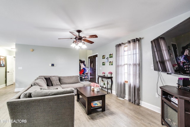 living room featuring ceiling fan and light hardwood / wood-style floors