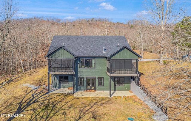 back of property featuring a sunroom, a yard, and a patio