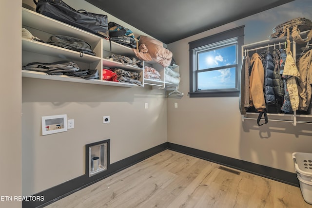 laundry room with hookup for an electric dryer, light hardwood / wood-style floors, and washer hookup