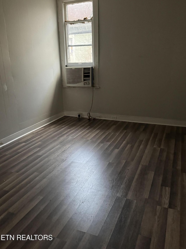 spare room with cooling unit and dark hardwood / wood-style flooring