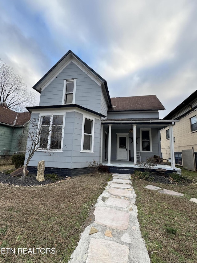 bungalow featuring a porch and a front lawn