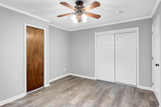 unfurnished bedroom with ceiling fan, light hardwood / wood-style floors, ornamental molding, and a textured ceiling