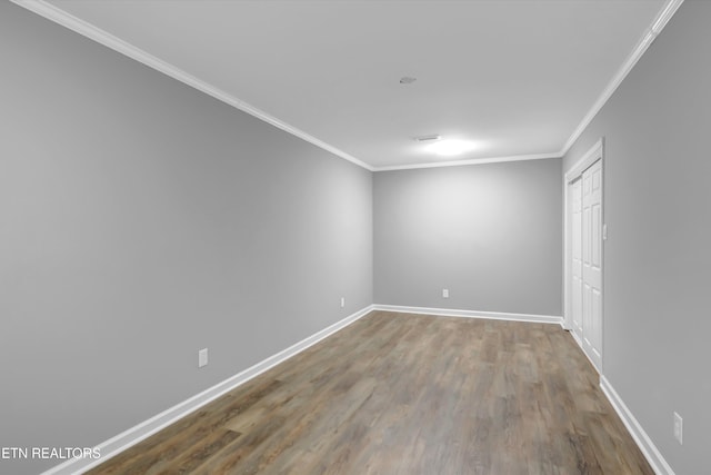 spare room featuring hardwood / wood-style flooring and ornamental molding