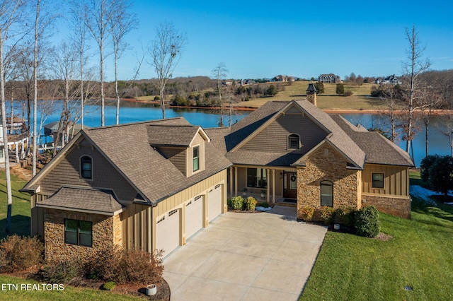 view of front facade with a water view, a garage, and a front yard