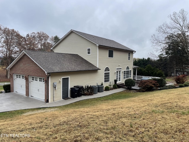 view of side of property with a garage and a lawn