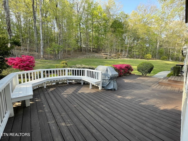 wooden deck featuring a lawn