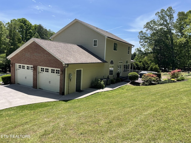 view of side of property with a lawn, a shingled roof, and brick siding