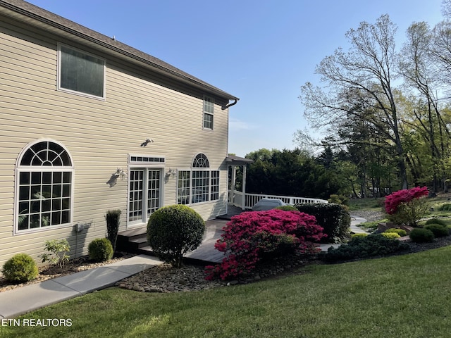 exterior space featuring a deck and a lawn