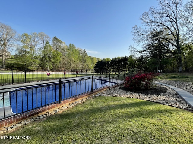 view of pool with a fenced in pool, fence, and a yard