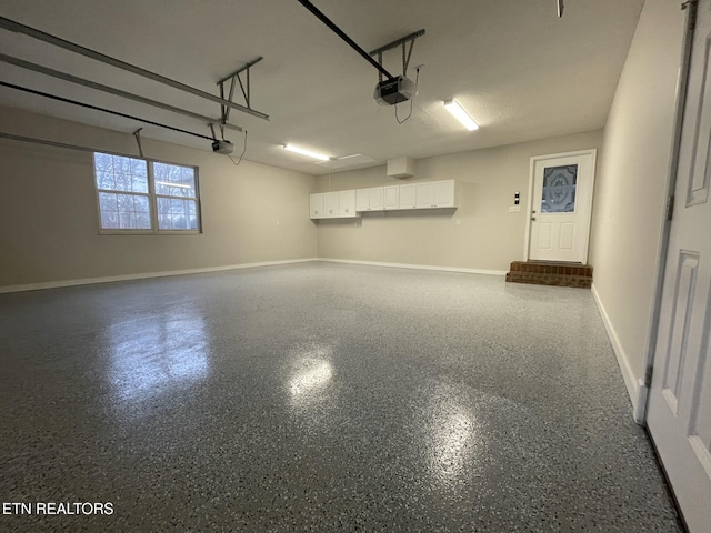 garage featuring a garage door opener and baseboards
