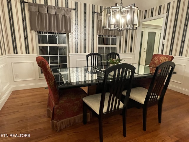 dining space featuring wallpapered walls, a wainscoted wall, an inviting chandelier, and a decorative wall