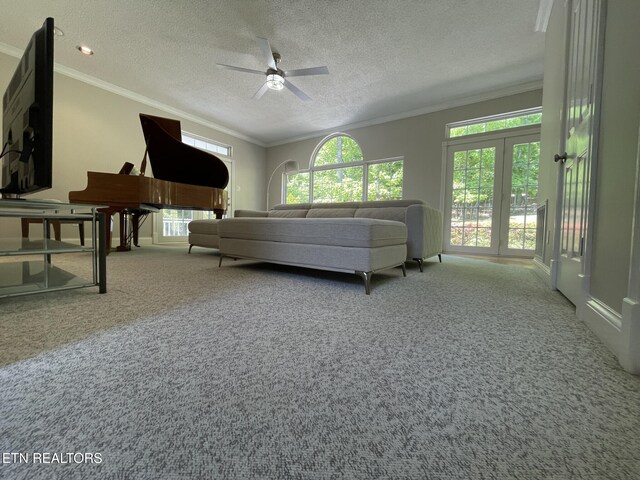 bedroom with crown molding, a textured ceiling, a ceiling fan, and carpet