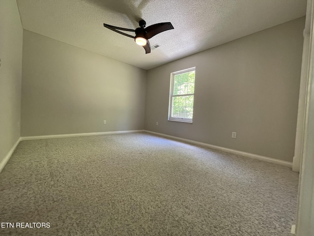 carpeted empty room with a textured ceiling, ceiling fan, visible vents, and baseboards