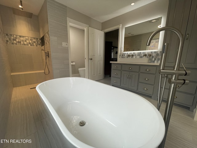 full bathroom with walk in shower, vanity, toilet, and a soaking tub