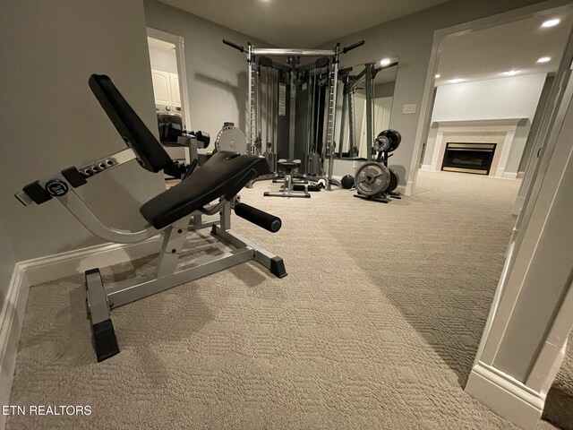 exercise room with a fireplace, baseboards, recessed lighting, and carpet floors