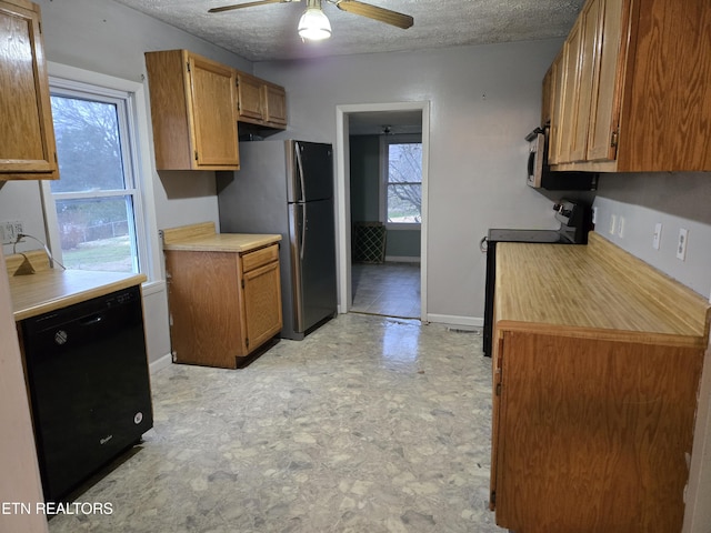 kitchen with dishwasher, stove, a textured ceiling, and stainless steel fridge