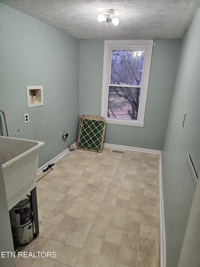 clothes washing area with washer hookup and a textured ceiling