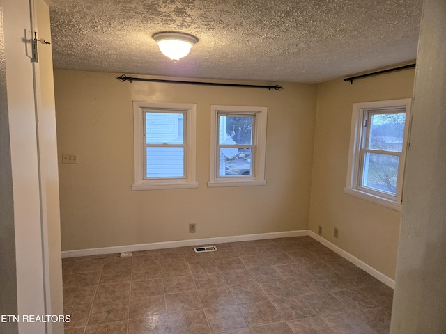 unfurnished room with a textured ceiling