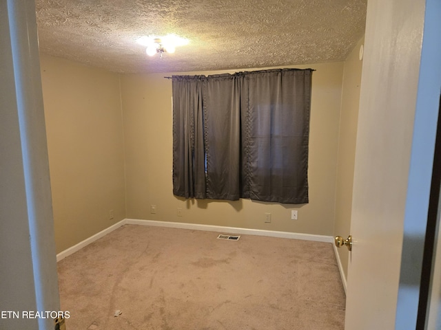 carpeted spare room with a textured ceiling