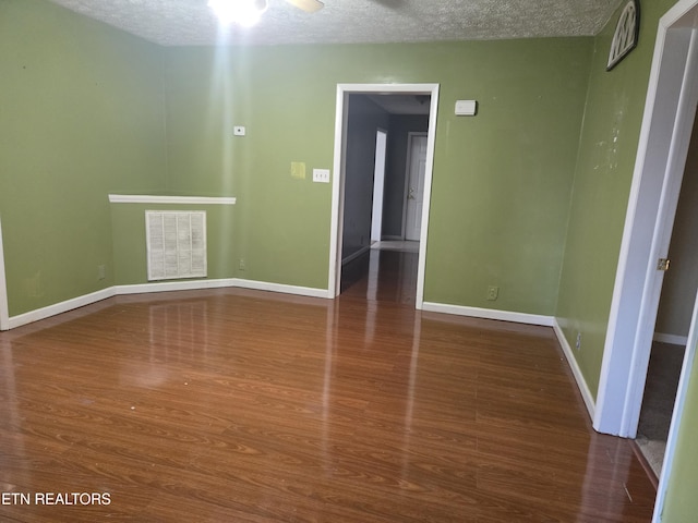 unfurnished room with wood-type flooring and a textured ceiling