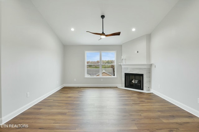 unfurnished living room with ceiling fan, a premium fireplace, and hardwood / wood-style floors