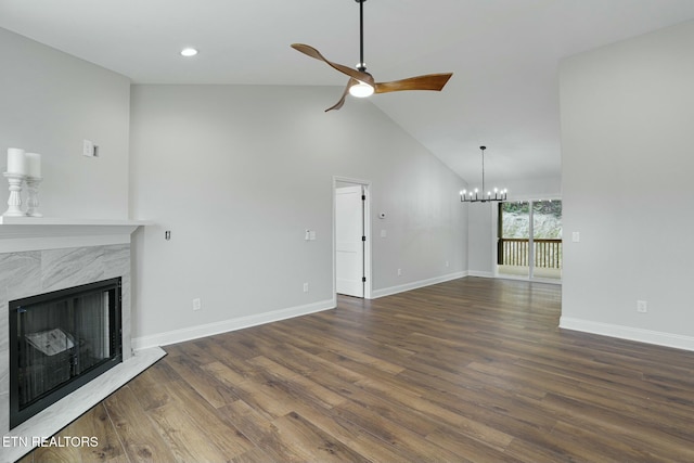 unfurnished living room featuring high vaulted ceiling, dark wood-type flooring, ceiling fan with notable chandelier, and a fireplace