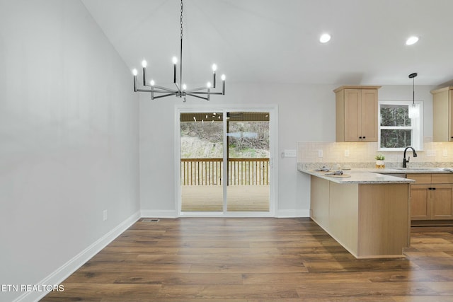 kitchen with pendant lighting, dark wood-type flooring, kitchen peninsula, and light brown cabinets