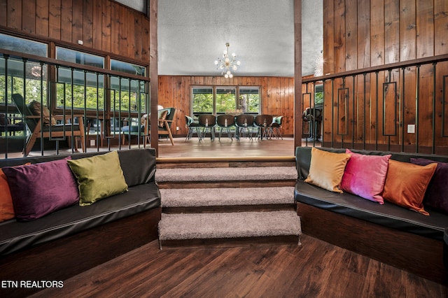 interior space with wooden walls, hardwood / wood-style floors, a chandelier, and a textured ceiling