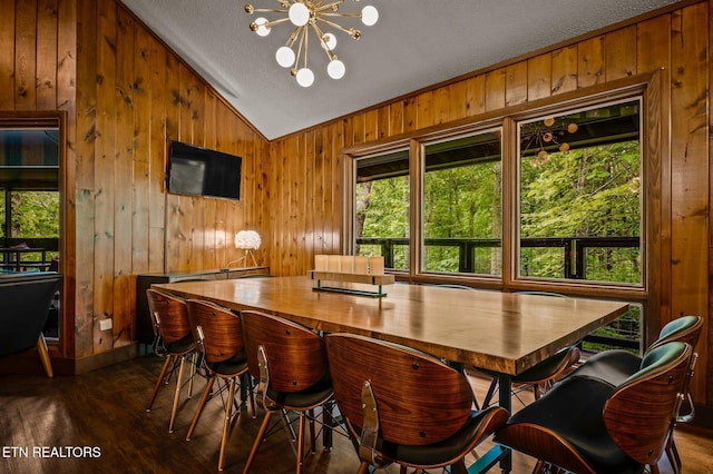 dining space featuring a textured ceiling, dark hardwood / wood-style flooring, a chandelier, and lofted ceiling