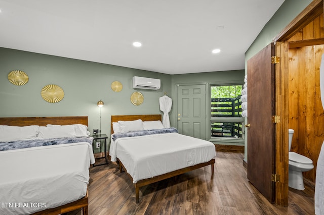 bedroom with an AC wall unit and dark wood-type flooring