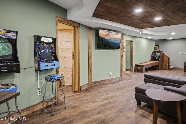 interior space featuring hardwood / wood-style floors, a raised ceiling, and wooden ceiling